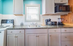 a kitchen with white cabinets and a sink at Bennett's Bungalow - S Nags Head MP 17, 30 Yds to Beach, Year Round Flex Stays in Whalebone
