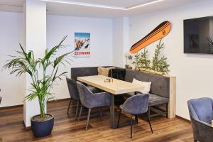 a table and chairs in a room with a surfboard on the wall at Hotel Hermitage in Sestriere