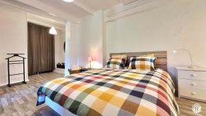 a bedroom with a bed with a colorful blanket at Les Hirondelles in Ouroux