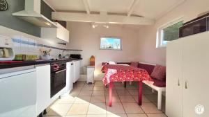 a kitchen with a table with a red table cloth on it at Les Hirondelles in Ouroux