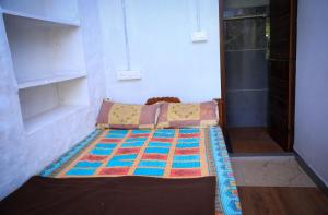 a bed with a quilt on it in a room at Sree vinayaka homestay in Vagamon
