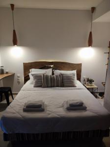 a bedroom with a large bed with two towels on it at Reborn Project Acropolis in Skiathos