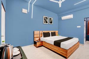 a bedroom with a bed with a blue wall at Super Hotel O Daysinn Premium in Bhubaneshwar