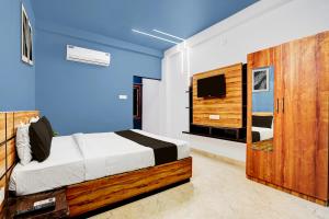a bedroom with a bed and a tv in a room at Super Hotel O Daysinn Premium in Bhubaneshwar