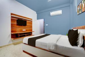 a bedroom with a bed and a tv on a wall at Super Hotel O Daysinn Premium in Bhubaneshwar