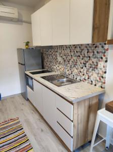 a kitchen with white cabinets and a sink at Reborn Project Acropolis in Skiathos