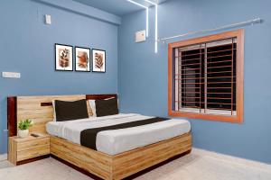 a blue bedroom with a large bed with a window at Super Hotel O Daysinn Premium in Bhubaneshwar