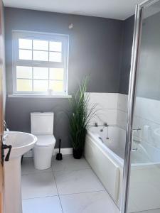 a bathroom with a toilet and a tub and a sink at Clones Town House in Cluain Eois +11 photos