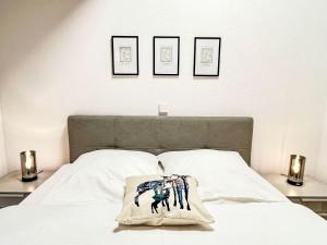 a bedroom with a white bed with three pictures on the wall at Apartment Feingeist by Interhome in Löffingen