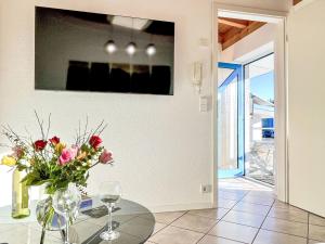 a dining room with a glass table with a vase of flowers at Apartment Feingeist by Interhome in Löffingen +18 photos