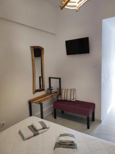 a bedroom with a bed and a chair and a mirror at Reborn Project Acropolis in Skiathos