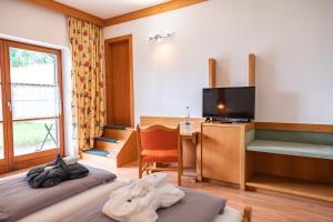 a hotel room with two beds and a television at Neubichler Alm in Piding
