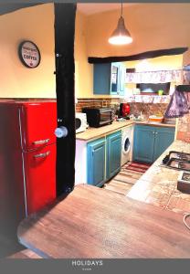 a kitchen with blue cabinets and a red refrigerator at IL Vicoletto in Serra San Bruno