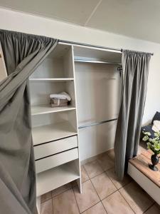 a closet with white shelves and a curtain at Le Nid du Centre in Anzin