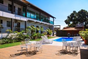 a group of chairs and a table in front of a building at Pousada Recanto das Águas - Fama MG in Fama +50 photos