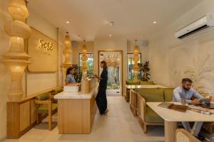 a woman standing at a counter in a restaurant at Sere Resort Goa in Goa