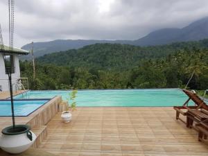 a swimming pool with mountains in the background at Riverston view hostel in Matale