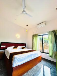 a bedroom with a large bed and a window at Flymount Homestay in Vagamon