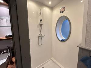 a bathroom with a shower and a round window at Marton Lodge in Bridlington