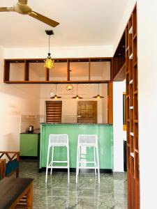 a kitchen with a green counter and two stools at Flymount Homestay in Vagamon +8 photos