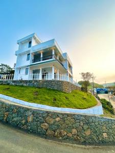 a large house on a hill with a stone wall at Flymount Homestay in Vagamon