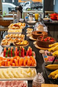 a table topped with lots of different types of food at Vektor Hotéis - Unidade Mariana in Mariana