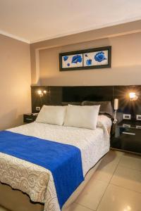 a bedroom with a large bed with a blue blanket at Hotel Everest in Córdoba +29 photos