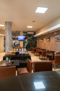 a restaurant with tables and chairs and a tv at Hotel Everest in Córdoba