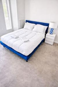 a large bed with a blue frame in a bedroom at Cobalt Cove (132) in Des Moines