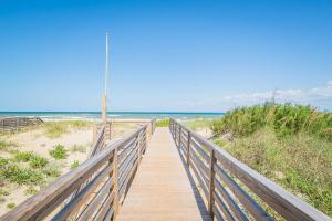 a boardwalk to the beach with the ocean in the background at Pier Pleasure - S Nags Head MP 17, Oceanfront, Private Beach Access, Ocean View, Fireplace in Whalebone