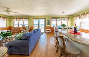 a living room with a blue couch and a table at Pier Pleasure - S Nags Head MP 17, Oceanfront, Private Beach Access, Ocean View, Fireplace in Whalebone