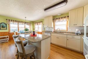 a kitchen with a large island with chairs in it at Pier Pleasure - S Nags Head MP 17, Oceanfront, Private Beach Access, Ocean View, Fireplace in Whalebone