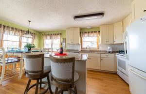 a kitchen with a counter and a table with chairs at Pier Pleasure - S Nags Head MP 17, Oceanfront, Private Beach Access, Ocean View, Fireplace in Whalebone