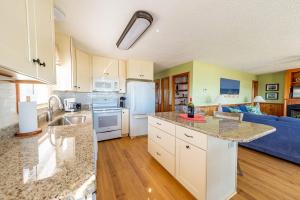 a kitchen with white appliances and a blue couch at Pier Pleasure - S Nags Head MP 17, Oceanfront, Private Beach Access, Ocean View, Fireplace in Whalebone +44 photos