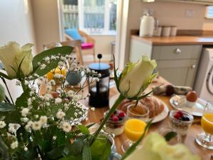 a dining room table with flowers and oranges on it at Atte Combe Cottage, Hadrian Wall Country in Acomb +17 photos
