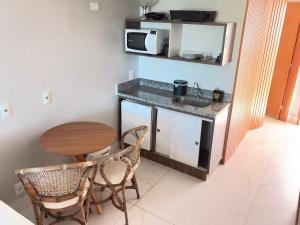 a small kitchen with a table and a microwave at Flat em Cabo Branco - Blue Sunset in João Pessoa