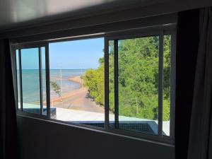 a room with a window with a view of the ocean at Flat em Cabo Branco - Blue Sunset in João Pessoa