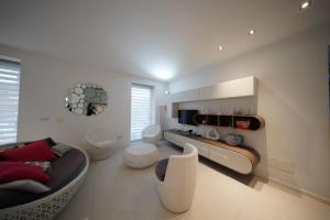 a living room with a couch and some chairs at Eden Luxury Villa in Focene