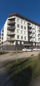 a large white building with cars parked in front of it at Apartman Mikulic 2 in Subotica