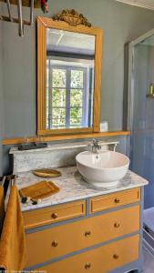 a bathroom with a sink and a mirror on a dresser at La Closerie des Anges in Saulx-de-Vesoul +34 photos