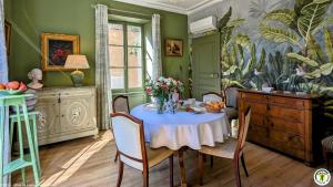 a dining room with a table with flowers on it at La Closerie des Anges in Saulx-de-Vesoul
