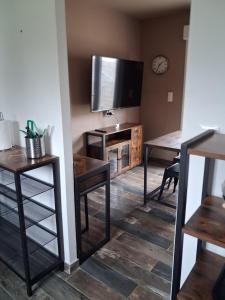 a living room with a flat screen tv and tables at Maison du causse in Magalas