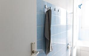 a blue tiled bathroom with a towel hanging on the wall at BEGE APARTMENTS ComfortLoft in Unna +24 photos