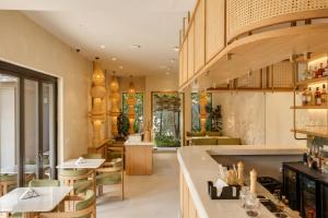 a restaurant with a bar and tables and chairs at Sere Resort Goa in Goa +81 photos