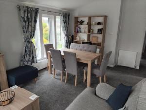a living room with a dining room table and chairs at Luxury 3 bed lodge, Skegness - East Coast Holidays in Winthorpe +7 photos