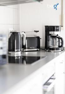 a kitchen counter with two coffins and a coffee maker at BEGE APARTMENTS ComfortLoft in Unna