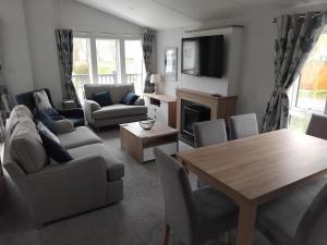a living room with a couch and a table and chairs at Luxury 3 bed lodge, Skegness - East Coast Holidays in Winthorpe