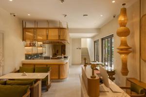 a restaurant with tables and chairs and a kitchen at Sere Resort Goa in Goa