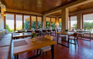 a restaurant with tables and chairs and windows at Villa Maria Caetana in Frazão
