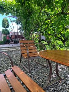 two wooden benches sitting next to a picnic table at Cottage EcoComfort in Sagunovka